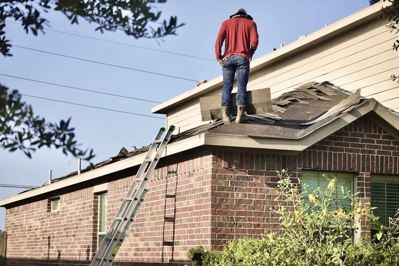 Professional roofer working on a residential roof in Falls Village